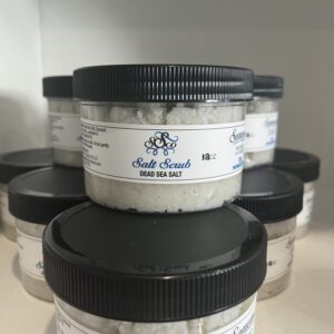 Several jars of white cream with black lids, labeled in foreign text.