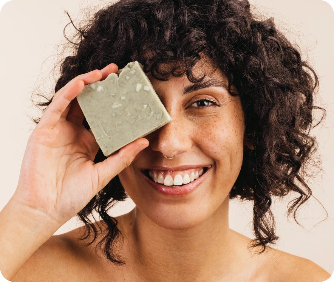 Woman playfully covering eye with soap